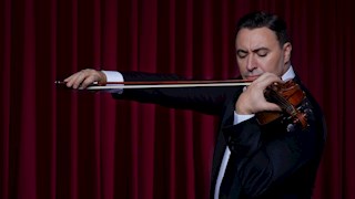 Maxim Vengerov wearing a suit playing the violin 