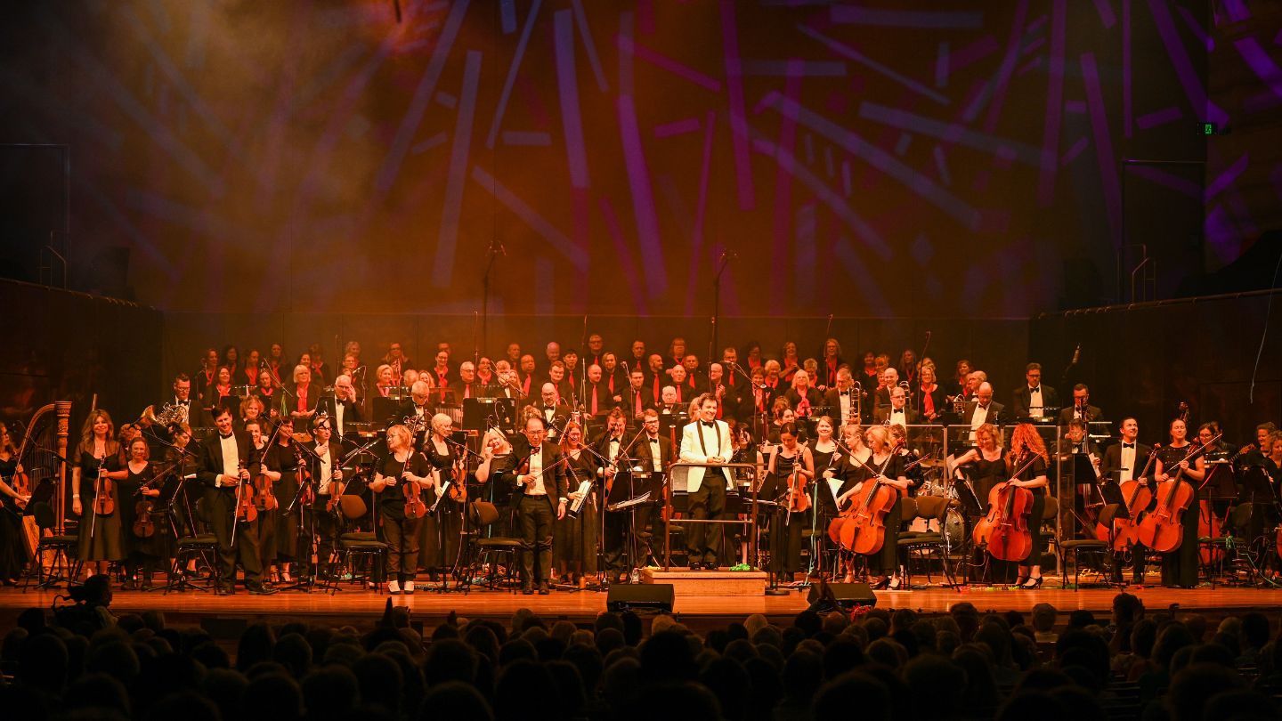 A large orchestra seated on stage