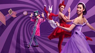 Four characters are standing in front of a purple spiral background. In the front is Alice wearing a purple dress. Behind her is a ballerina wearing a red outfit. Then a character wearing a top hat and colour outfit is standing with his arms in the air, followed by a character with white hair jumping in the background. a clock and playing cards are also flying in the air.