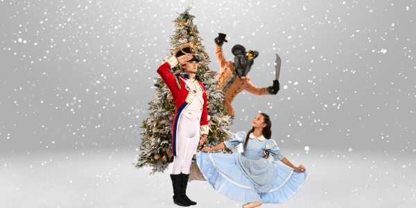 A young girl and a solider from The Nutcracker are standing in front of a Christmas tree. A mouse is standing behind the charismas tree holding a knife. It is snowing.